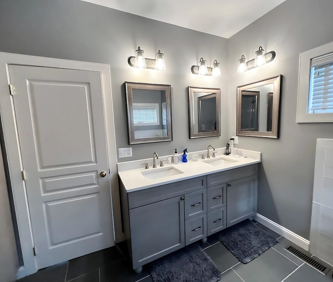bathroom rebuild Berlin Modern bathroom remodel featuring a double vanity with gray cabinets, quartz countertop, dual mirrors, and contemporary lighting — completed by Central Connecticut Building & Remodeling in Berlin, CT.